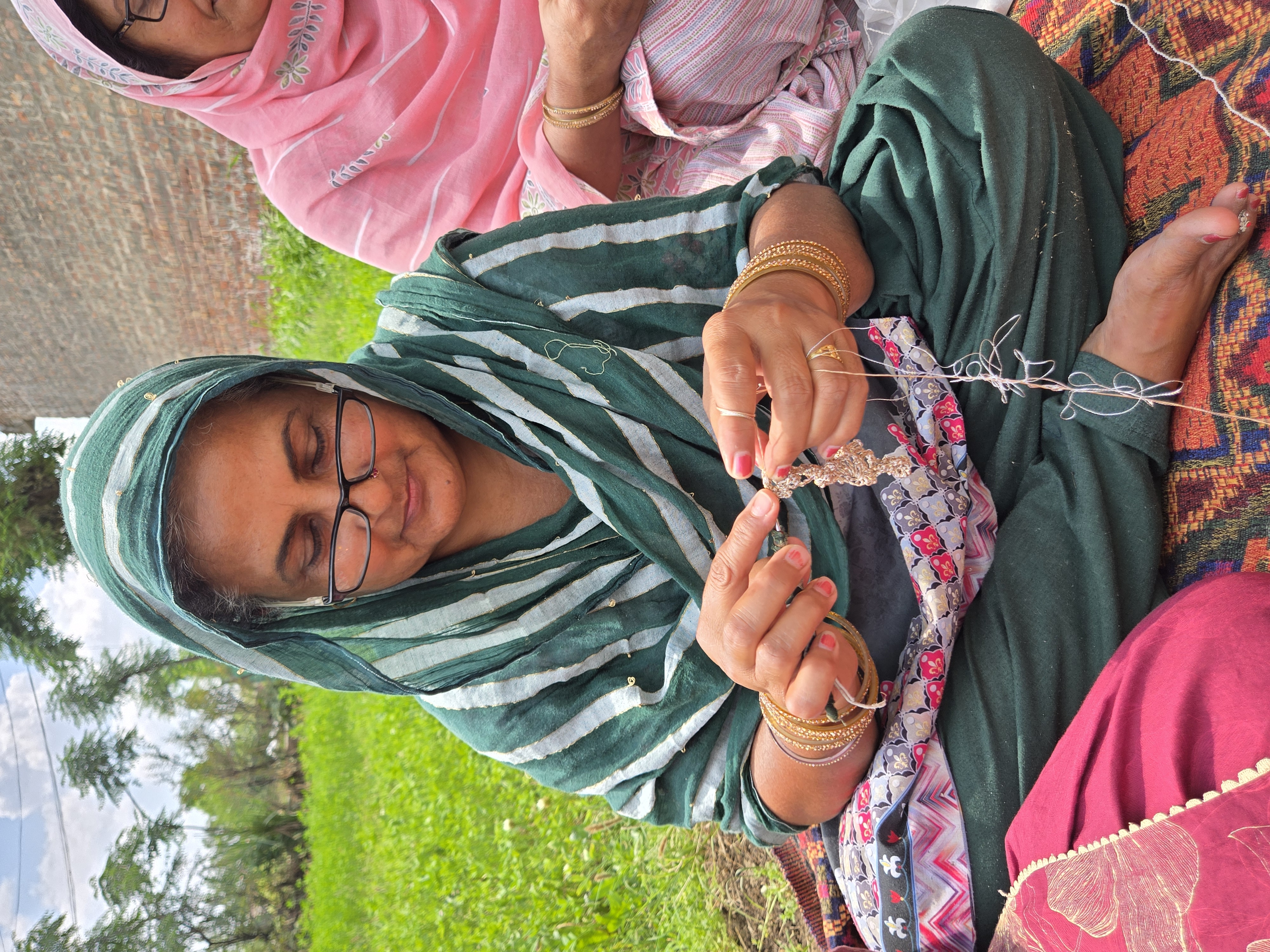 Women artisans crocheting together in golden hour light