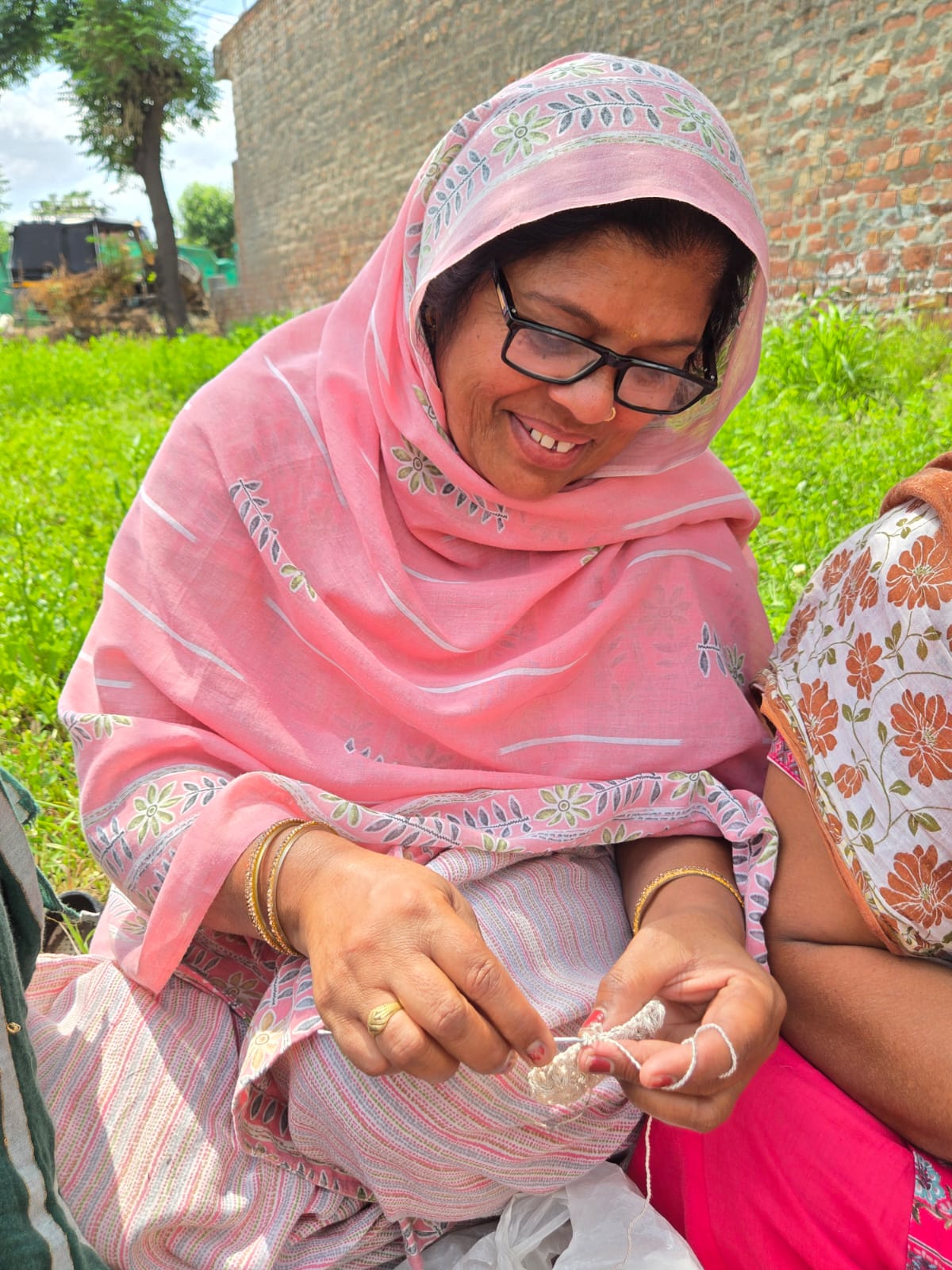 Women artisans crocheting together in golden hour light
